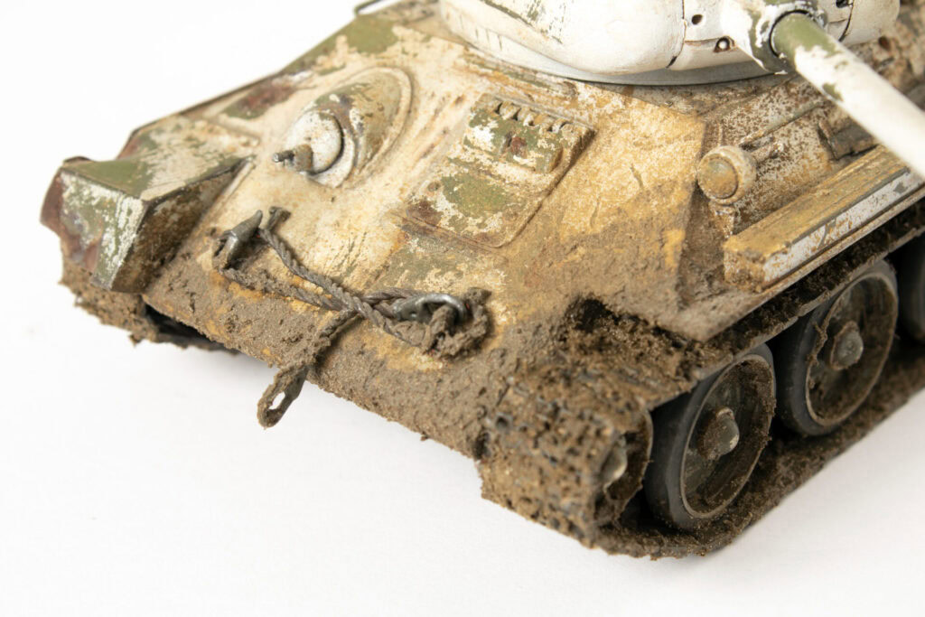 Oštećen vojni model, star i zaprljan, sa blatom i ogrebotinama.